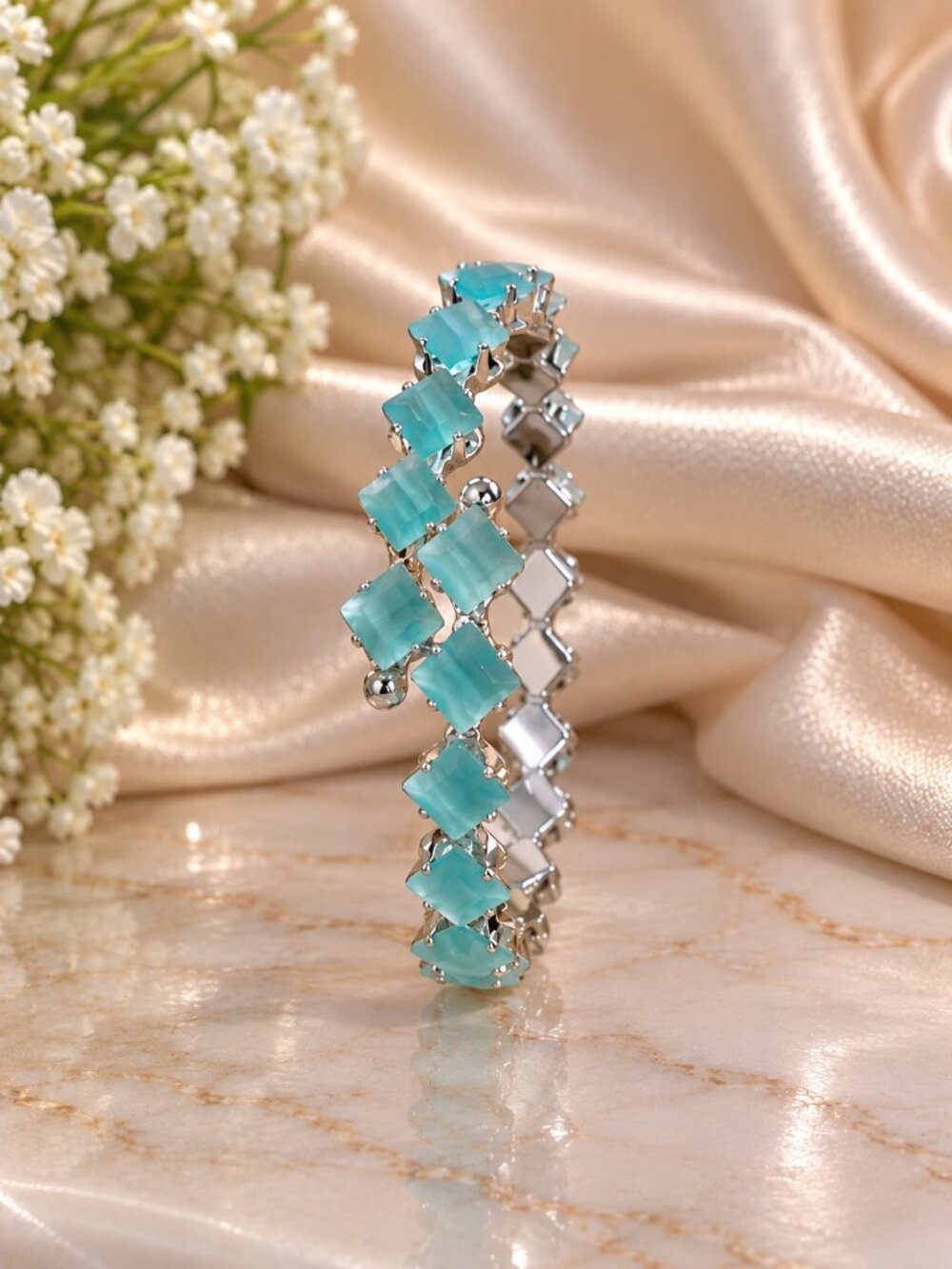 Silver-tone bracelet featuring soft aqua-blue square stones